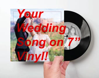 May include: A 7-inch black vinyl record featuring a square cover with a photograph of a couple in formal attire. The text "Your Wedding Song on 7" Vinyl!" is printed in large red letters across the center of the image, partially overlapping the record.