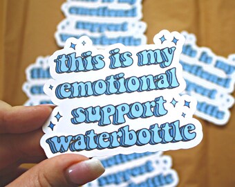May include: A blue and white sticker with the text "This is my emotional support waterbottle" in a retro font. The sticker has small white stars around the text.