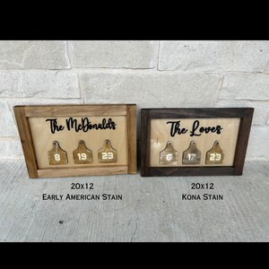 May include: Two wooden signs with the names "The McDonalds" and "The Loves" in black lettering. Each sign has three wooden tags with numbers on them. The sign on the left is stained in an Early American stain and the sign on the right is stained in a Kona stain. Both signs are 20 inches by 12 inches.