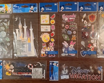 May include: A set of ten Disney sticker packs featuring various characters and themes, including Cinderella's castle, Mickey Mouse, Minnie Mouse, and a fruit stand. The sticker packs are packaged in clear plastic bags with a Disney logo and the number of stickers included.
