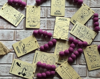 May include: A collection of religious educational cards with illustrations and text, connected by strings of purple felt balls. The cards depict scenes from the Bible, including "Jesus Enters Jerusalem" and "The Greatest Commandment".
