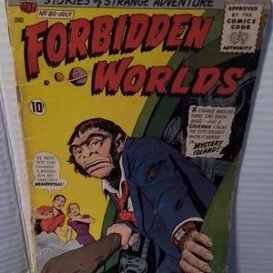 May include: A vintage Forbidden Worlds comic book, number 80, dated July. The cover features a Neanderthal in a suit holding a club, with text reading "He went into that chamber a modern man and came out a Neanderthal!" and "Mystery Island!"