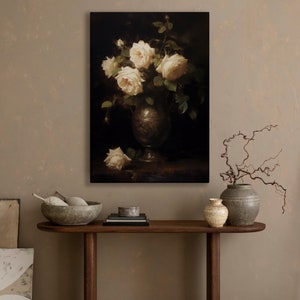 May include: A painting of a bouquet of white roses in a silver vase. The roses are arranged in a loose, natural style, and the vase is decorated with a simple design. The background is a dark, muted color.