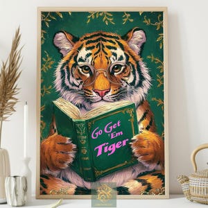 May include: A framed print featuring a tiger wearing glasses and reading a book. The book is green with the text "Go Get 'Em Tiger" in pink. The tiger has orange and black stripes and is set against a green background.
