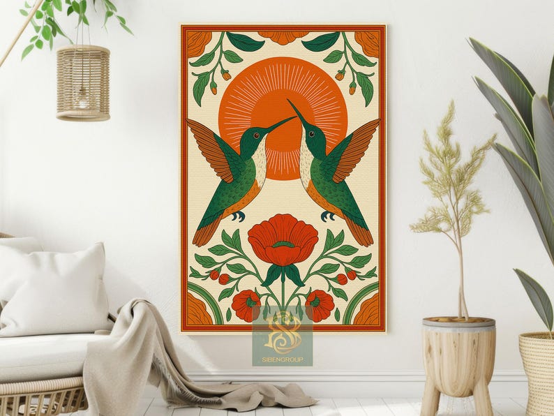 May include: A framed art print featuring two hummingbirds with green and orange plumage, facing each other. The birds are set against a cream background with an orange sunburst design. Red flowers and green foliage frame the birds.