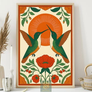 May include: Framed art print featuring two green and brown hummingbirds facing each other, with a large orange sun in the background. The artwork includes red flowers and green foliage, all within a decorative border.
