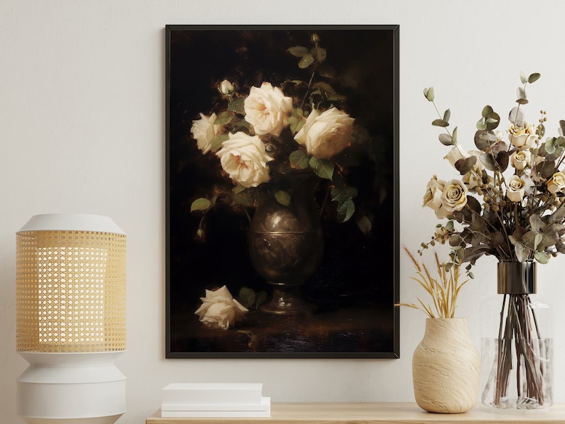 May include: A framed painting of a still life featuring a bouquet of white roses in a silver vase against a dark background.