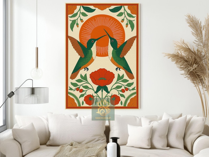 May include: A framed art print featuring two hummingbirds facing each other, with a red flower and sun design. The birds are green and orange, set against a cream background with an orange border. The artwork is displayed on a wall above a sofa.