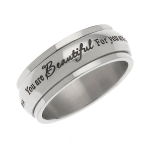 May include: A silver spinning ring with the inscription "You are Beautiful For you are" engraved on the band.