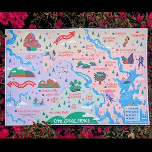 May include: A colorful map print featuring various climbing locations with illustrations of mountains, rivers, and climbers. The map includes text such as "DMV Local Crags" and location names like "Red River Gorge" and "The Gunks."