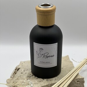 May include: Black diffuser bottle with a wooden lid and a white label that says "La Roseraie lychee peony".