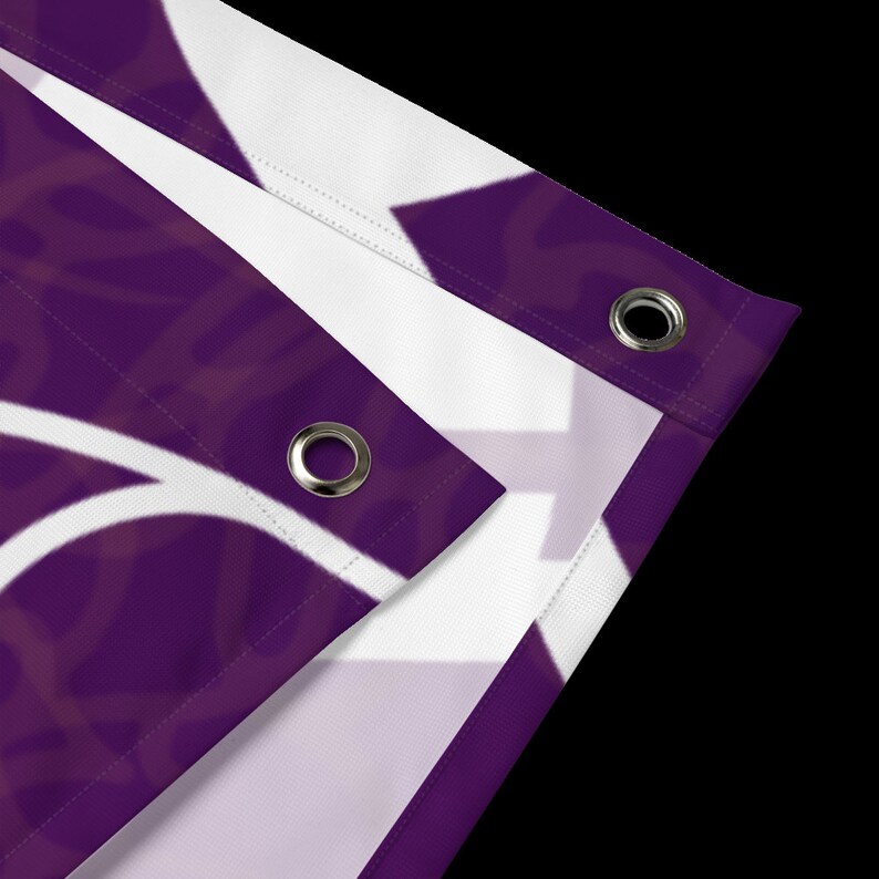 May include: Close-up of a purple fabric banner with white eyelets. The banner has a white design on it.