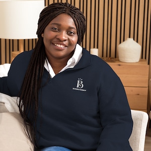 May include: A navy blue sweatshirt with a white embroidered logo that says "Blessed Hebrew" and a crown above the letter "B".