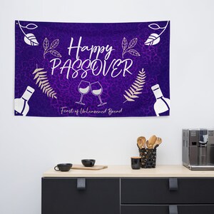 May include: Purple banner with the text "Happy Passover Feast of Unleavened Bread" in white lettering. The banner also features two wine glasses clinking, a bottle of wine, and leafy branches.