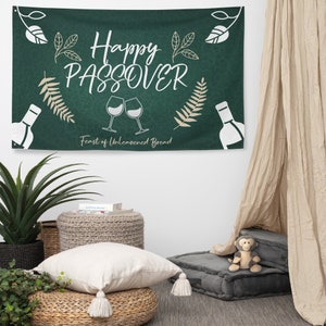 May include: Green banner with the text "Happy Passover Feast of Unleavened Bread" in white lettering. The banner has a leafy design and two wine glasses with a bottle on each side.
