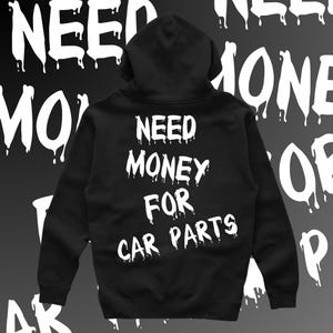 May include: Black hooded sweatshirt with white text that reads "NEED MONEY FOR CAR PARTS" in dripping letters.