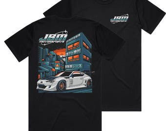 May include: Black t-shirt with a white car and Japanese text on the front. The text reads "JBM Motorsports".