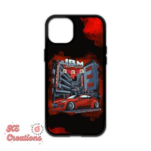 Peut inclure: Une coque de téléphone noire avec un motif rouge et noir. Le motif représente une voiture de sport rouge conduisant dans une rue de ville avec des bâtiments et des drapeaux coréens. Le texte "JBM Motorsports" et "KDM MOTORSPORTS" figurent sur la coque.