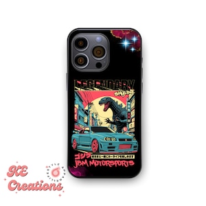 May include: A black iPhone case with a graphic of a Godzilla-like monster in a city setting. The monster is green and has red eyes. The city is a vibrant mix of pink, blue, and yellow. The text "LEGENDARY SKYLINE" is at the top of the graphic. The text "ゴジラ  JBM MOTORSPORTS" is at the bottom of the graphic.