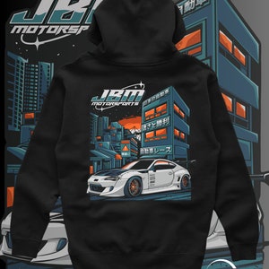 Puede incluir: Sudadera con capucha negra con un coche blanco y texto japonés en la espalda. El texto dice "Automóvil japonés, Velocidad y Victoria, Carrera de automóviles".