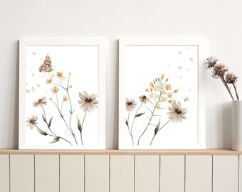May include: Two watercolor prints featuring delicate floral arrangements. The print on the left features a butterfly and white flowers with brown centers. The print on the right features yellow flowers and white flowers with brown centers.