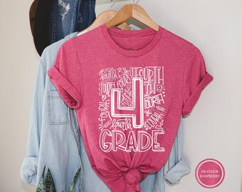 Puede incluir: Una camiseta de manga corta en color rosa frambuesa jaspeado con un gran estampado gráfico blanco. El diseño incluye un número cuatro prominente y el texto "FOURTH GRADE" rodeado de varios garabatos escolares como lápices y tijeras.