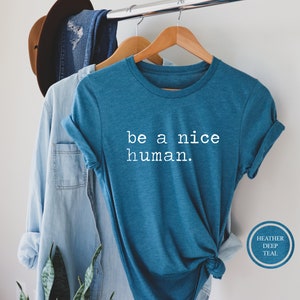 Pu&ograve; includere: Una maglietta blu turchese con la scritta "be a nice human." stampata in bianco sul davanti.
