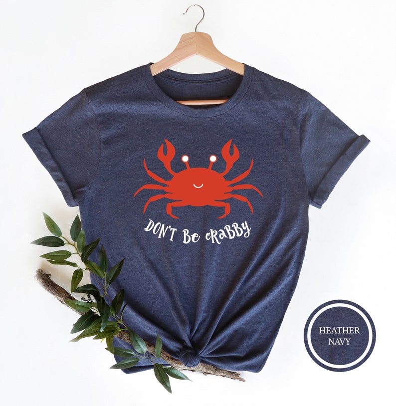 May include: A navy blue t-shirt with a red cartoon crab and the text "Don't be crabby".