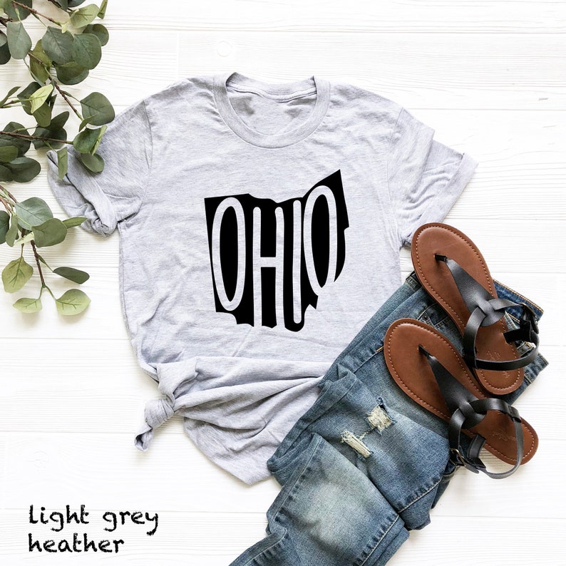 May include: A light grey heather t-shirt with a black graphic of the state of Ohio with the word "OHIO" inside the outline of the state.