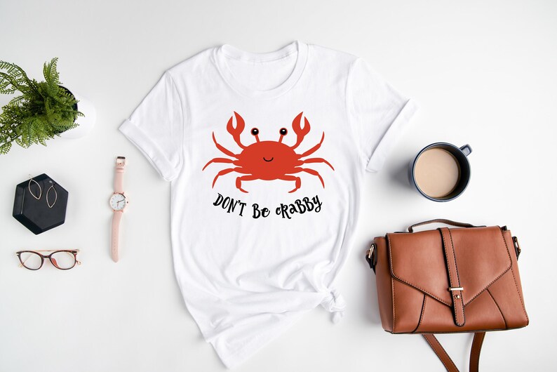 May include: White t-shirt with a red cartoon crab and the text "Don't be crabby".