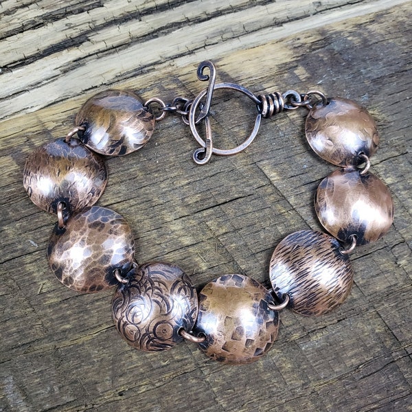 Copper disc bracelet, hammered and textured domed links finished with a patina