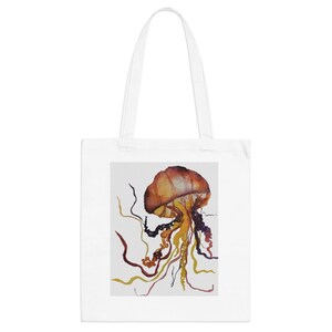 May include: A white tote bag featuring a watercolour illustration of a jellyfish. The jellyfish is orange, yellow and purple with long tentacles.