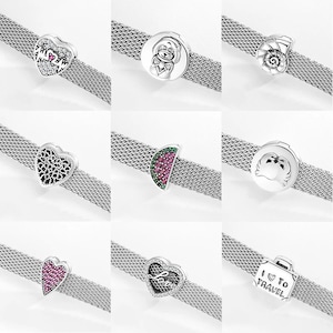 May include: Nine silver charm bracelets with different charms. The charms include a heart with the word "Mom" on it, a dog, a seashell, a watermelon slice, an apple, a heart with the word "Love" on it, and a suitcase with the words "I Love to Travel" on it.