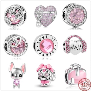 May include: A set of ten silver charm beads with pink accents. The charms include a heart with a bow, a skull with pink flowers, a heart with a heartbeat, a heart with wings, a flower, a suitcase, a dog, and a circle with the words "Love is Forever".