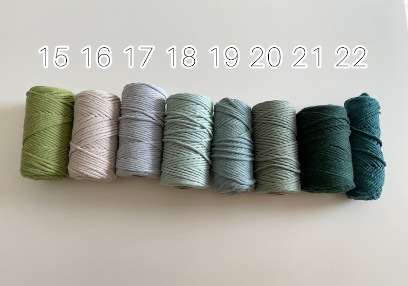 May include: Eight spools of cotton cord in various shades of green, blue, and beige. The spools are labelled with numbers 15 through 22.