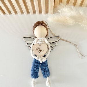 Può includere: Un ornamento di angelo in legno con pantaloni in crochet blu e un'etichetta di legno a forma di cuore che dice "Opa".