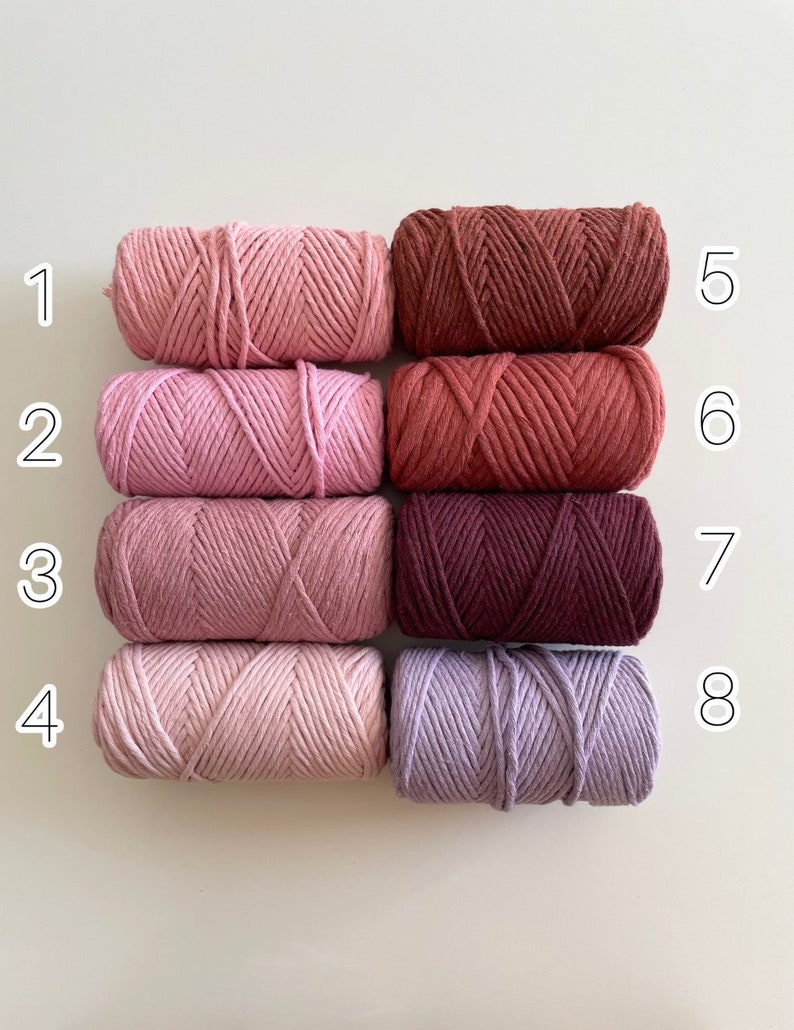 May include: Eight spools of cotton cord in various shades of pink, red, and purple. The spools are numbered 1 through 8.