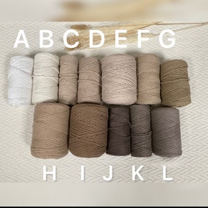 May include: A set of 12 spools of cotton rope in various shades of beige, brown, and grey. The spools are labelled A through L.
