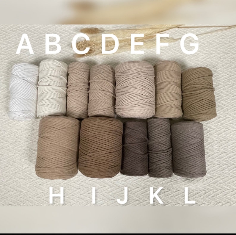 May include: A set of 12 spools of cotton rope in various shades of beige, brown, and grey. The spools are labelled A through L.