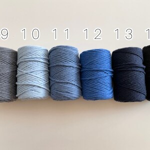 May include: Six spools of cotton cord in various shades of blue and grey. The spools are numbered 9 through 14.