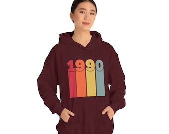 May include: A maroon hoodie with a vintage-style graphic of the year 1990 in rainbow colors.