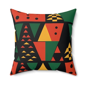 May include: A decorative pillow with a geometric pattern in black, red, yellow, and green. The pattern features triangles, squares, and circles.