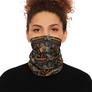 May include: A black face mask with a geometric pattern in shades of orange, yellow, blue, and white. The pattern is reminiscent of traditional African art.