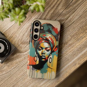 May include: A phone case featuring a vibrant portrait of a woman wearing a colorful head wrap and large hoop earrings. The artwork uses a palette of blues, yellows, and reds, with paint drip effects. The case has a camera module.