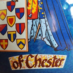 May include: A blue and white illustration featuring a knight holding a shield with various heraldic emblems. The text "of Chester" is displayed in a decorative banner. The artwork has a vintage, possibly antique, aesthetic.