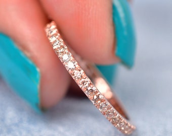 May include: A delicate rose gold band with a row of small, sparkling diamonds.
