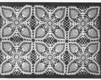 May include: A white, rectangular crocheted doily with a repeating pattern of fan-shaped designs and openwork diamonds. The intricate lace-like texture creates a delicate and ornate appearance. The doily is likely handmade.