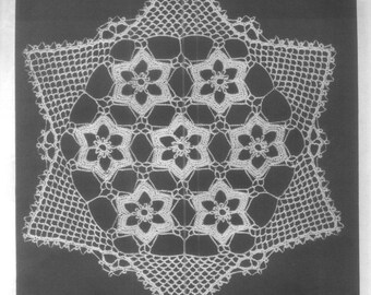 May include: A white crocheted doily featuring a hexagonal shape composed of seven interconnected star-shaped floral motifs. The central design is surrounded by a delicate openwork mesh border with a pointed, scalloped edge throughout the perimeter.
