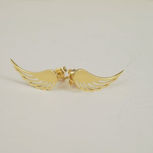 Puede incluir: Un par de pendientes de color dorado con forma de alas de &aacute;ngel. Las alas son delicadas y tienen un dise&ntilde;o recortado.