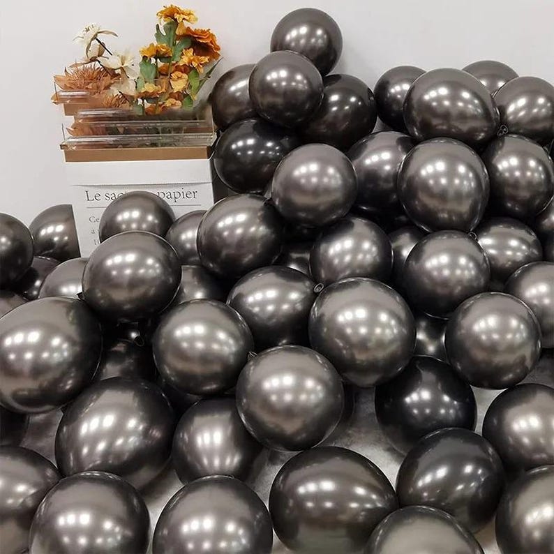 May include: A large group of metallic gray balloons. The balloons are shiny and have a reflective surface.